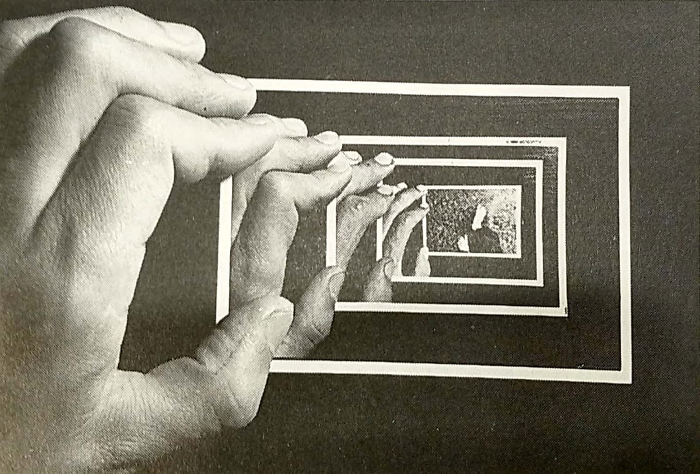 A hand holds a photograph that repeats within itself, by Isao Kota